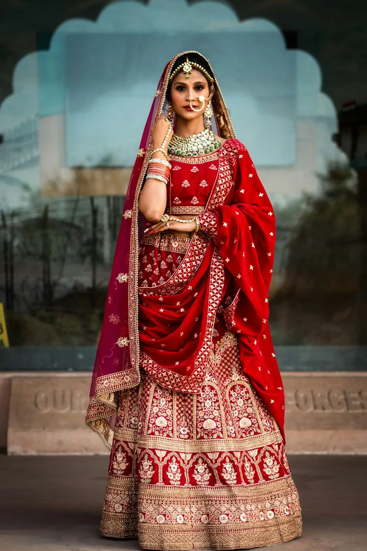 Bride in a red and gold embroidered bridal lehenga