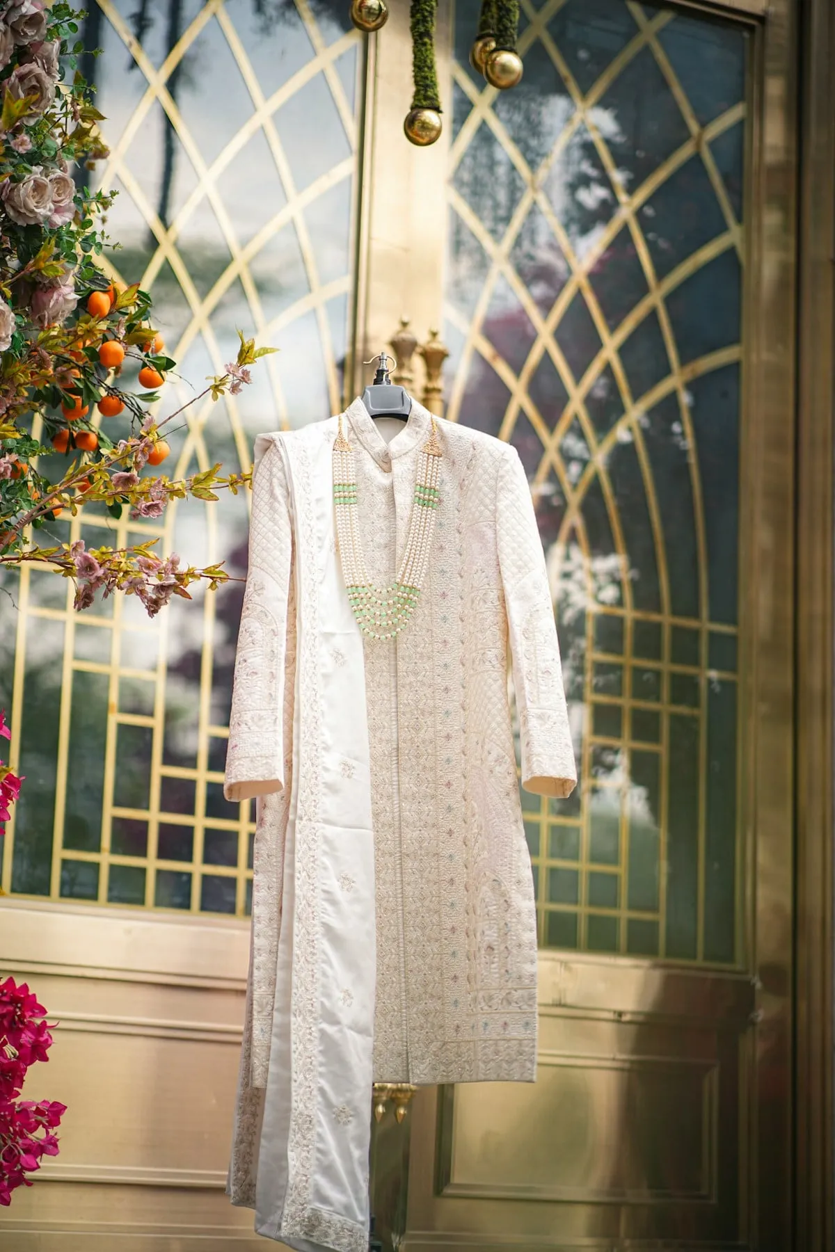 Ivory embroidered sherwani on a hanger in a boutique
